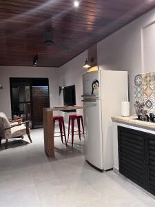 eine Küche mit einem Kühlschrank und einem Tisch mit Stühlen in der Unterkunft Loft Refúgio in Angra dos Reis