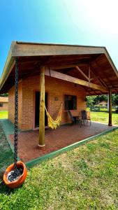 a pavilion with a hammock in front of a house at Chalés Bons Ventos in São Bento do Sapucaí
