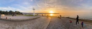 a group of people standing on a beach near the water at Appartamento Da Andrea in Izola