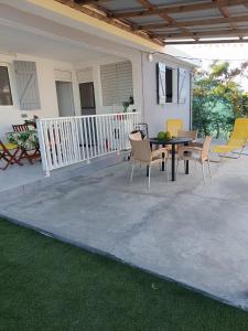 Un patio con una mesa y sillas en una casa. en Résidence belle place, en Saint-François