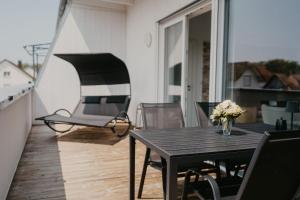 a balcony with a wooden table and a chair at Luxus Penthouse Apartment Europa-Park in Lahr