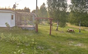 a cabin with a picnic table and a bench in a field at Domek Rogalewo in Wiele +6 photos