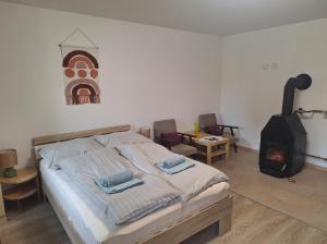 a bedroom with a bed and a wood stove at Őrségi Szent Márton Lak in Hegyhátszentmárton