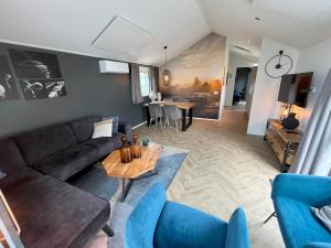 un soggiorno con un divano e un tavolo di De IJssel Eilanden Chalet Steghouse mit Zaun Nr 546 a Kampen