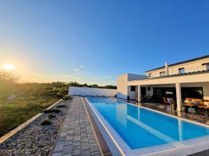 a swimming pool in front of a house at Luxury Villa Triton in Novalja