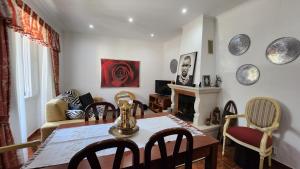 a living room with a table and chairs and a fireplace at BLISS BOHO HOUSE in Sintra