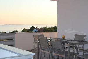 Una mesa y sillas en un balcón con vista al mar. en Ferienwohnung Villa Milla, en Vir 3 fotos más