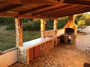 Un horno de pizza al aire libre en un patio de piedra. en Ferienwohnung Villa Milla, en Vir