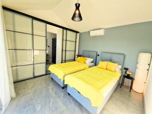 a bedroom with two beds with yellow pillows at Luxury Villa Triton in Novalja +22 photos