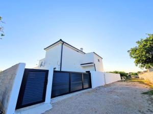 a white house with a garage door at Luxury Villa Triton in Novalja
