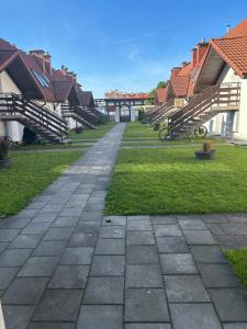 a walkway in the middle of a yard with houses at Studio przy plaży in Giżycko