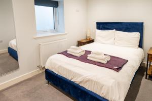Un dormitorio con una cama con toallas. en Town Centre Duplex 4, en Harrogate