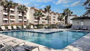 a swimming pool with chairs and a hotel at Southern Serenity, an HHI Beachfront Resort in Hilton Head Island