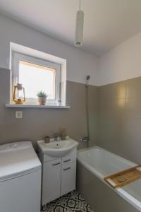 a white bathroom with a sink and a tub and a sink at Apartament w Górach Beskid Niski in Gładyszów