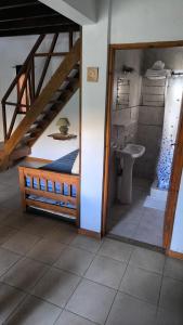 a bathroom with a bed and a sink in a room at Cabaña Negusa in Merlo