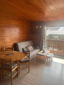 a living room with a couch and a table at Cozy apartment in Arâches-la-Frasse