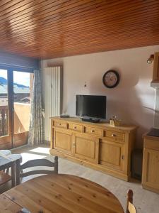 a living room with a television on a wooden dresser at Cozy apartment in Arâches-la-Frasse +3 photos