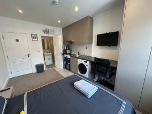 a room with a bed and a desk and a kitchen at Bright Modern, Private Apartment,15 Mins To Central London in Hendon