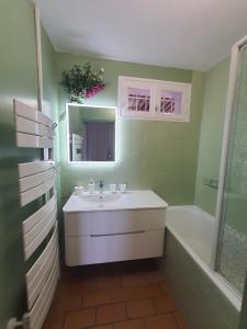 un bagno con un lavandino, una vasca e uno specchio di Vue mer à la plage du Môle - Clim - Fibre Wifi a Cap d'Agde Altre 33 foto