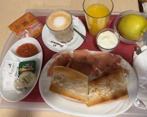 a tray of food with a plate of bread and a cup of coffee at posada carral cabarceno in La Concha