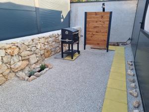 a backyard with a grill and a stone wall at Mobile home Marina in Drage