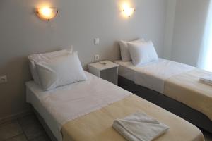 a hotel room with two beds with towels on them at Stefania rooms in Ligia
