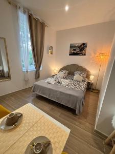 a bedroom with a bed and a large window at La Perle in Narbonne