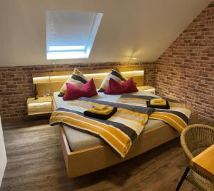a bedroom with a large bed with colorful pillows at Pension Rieslingakademie in Mesenich