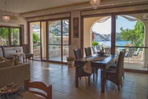 a dining room with a table and chairs with a view at Apartment Villa Omega in Agia Pelagia