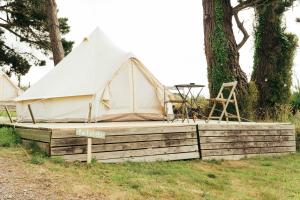 坡隆维茨普尔扎伊The Glamping Spot - Douarnenez的帐篷坐落在树旁的木制平台上