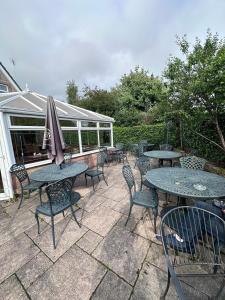 a patio with tables and chairs and an umbrella at The Villa Hamilton in Hamilton
