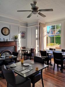 a dining room with tables and chairs and a fireplace at Bodnant Guest House in Llandudno