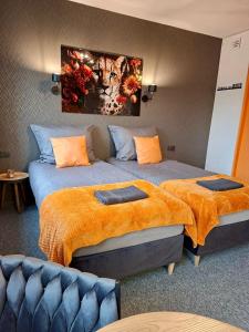 a bedroom with two beds with orange blankets at Orange Studio z kuchnią i łazienką in Koszalin +10 photos