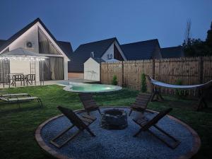a backyard with chairs and a fire pit and a fence at Mountain Resort Gabala in Nourkyshlak