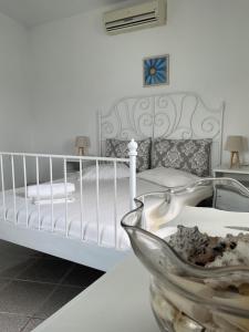 a white bedroom with a bed and a bowl on a table at Romantic Stone Villa in Samos