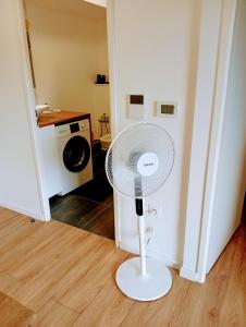 a white fan sitting on the floor in a room at Appartement deux pièces cosy in Asnières-sur-Seine
