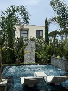 a swimming pool with two chairs and a house at Villa MarYsol - San Pietro Resort - Pool & Hot Tub in Durrës