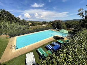 an image of a swimming pool with chairs and an umbrella at Villa Paradiso - Piscina, Parcheggio e Privacy in Pian D'artino