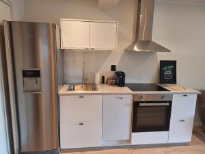 a kitchen with a stainless steel refrigerator and a sink at Fjord Nest in Bergen