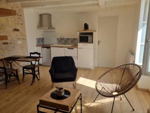 eine Küche und ein Wohnzimmer mit Tisch und Stühlen in der Unterkunft le gîte AGVP in Civaux