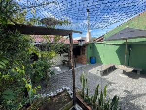a garden with a patio with an umbrella and a bench at Cantinho de São Chico in São Francisco do Sul