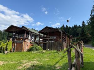 une maison en bois avec une clôture devant elle dans l'établissement 50m od Jeziora Holender, à Zawóz