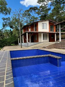 a blue tile pool in front of a house at Finca de Majo in Mocoa