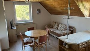 a living room with a table and a couch at Apartmán Hanka in Rožnov pod Radhoštěm