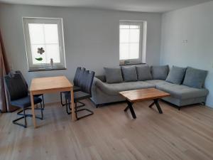 a living room with a couch and tables and two windows at Marktperle in Sagard