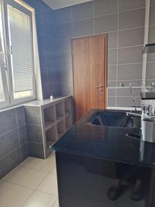 a bathroom with a black sink and a wooden door at Luxury Apartment Vadaš in Štúrovo +8 photos