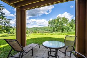 a patio with a table and chairs and a view of a field at Cozy 1 Bedroom Condo Holiday Valley in Ellicottville