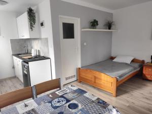 a small bedroom with a bed and a kitchen at Morska Fala in Sarbinowo