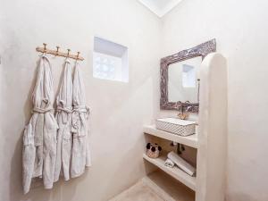 a white bathroom with a sink and a mirror at Riad Sifaw & Spa Marrakech in Marrakech +37 photos