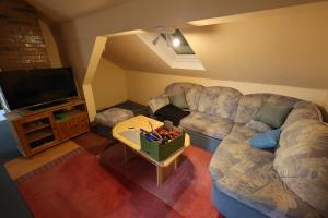 a living room with a couch and a tv at Pension Central in Bad Endbach
